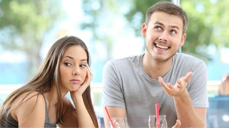 Couple having a serious conversation while sitting apart, symbolizing emotional distance in a relationship.
