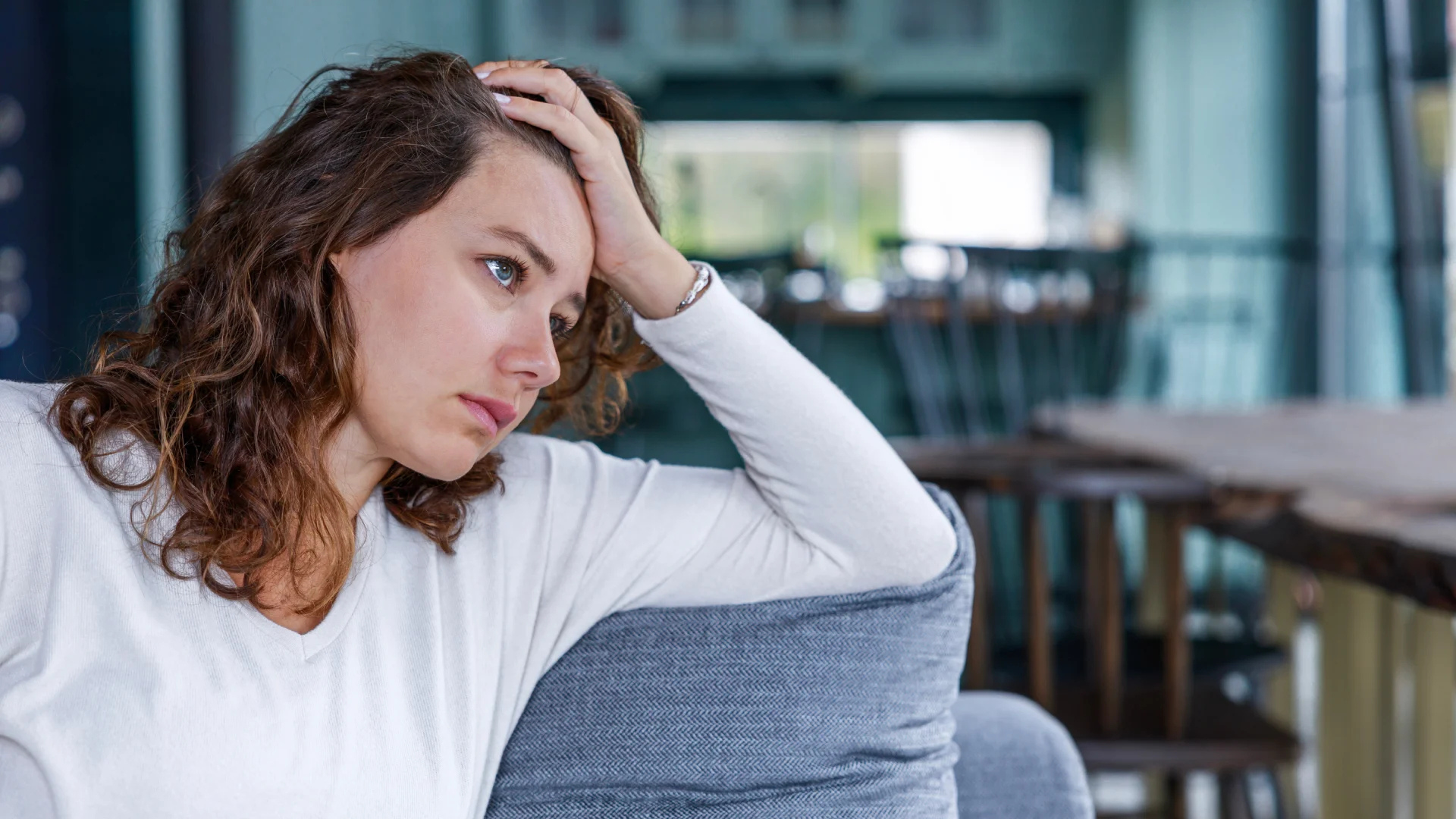 A thoughtful person sitting alone after an argument while their partner turns away, symbolizing relationship struggles and emotional imbalance.