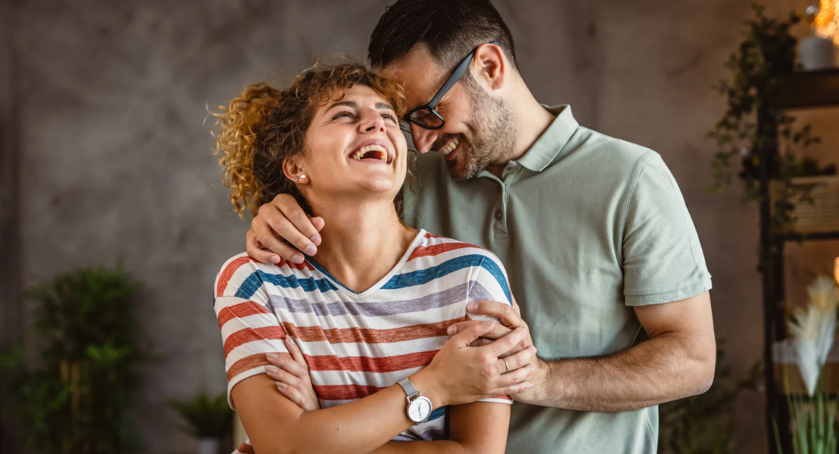 A married couple smiling and holding hands while enjoying a meaningful moment together, representing lasting love and emotional connection.