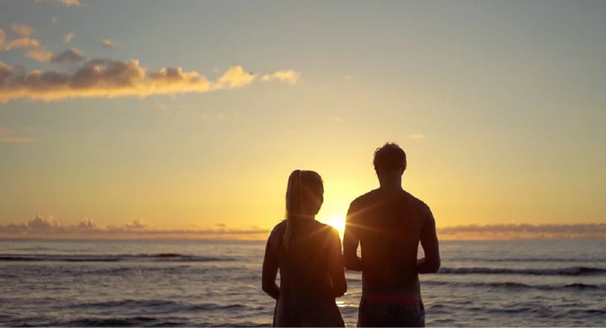 Couple smiling during a video call while in a long-distance relationship, staying emotionally connected despite living apart.