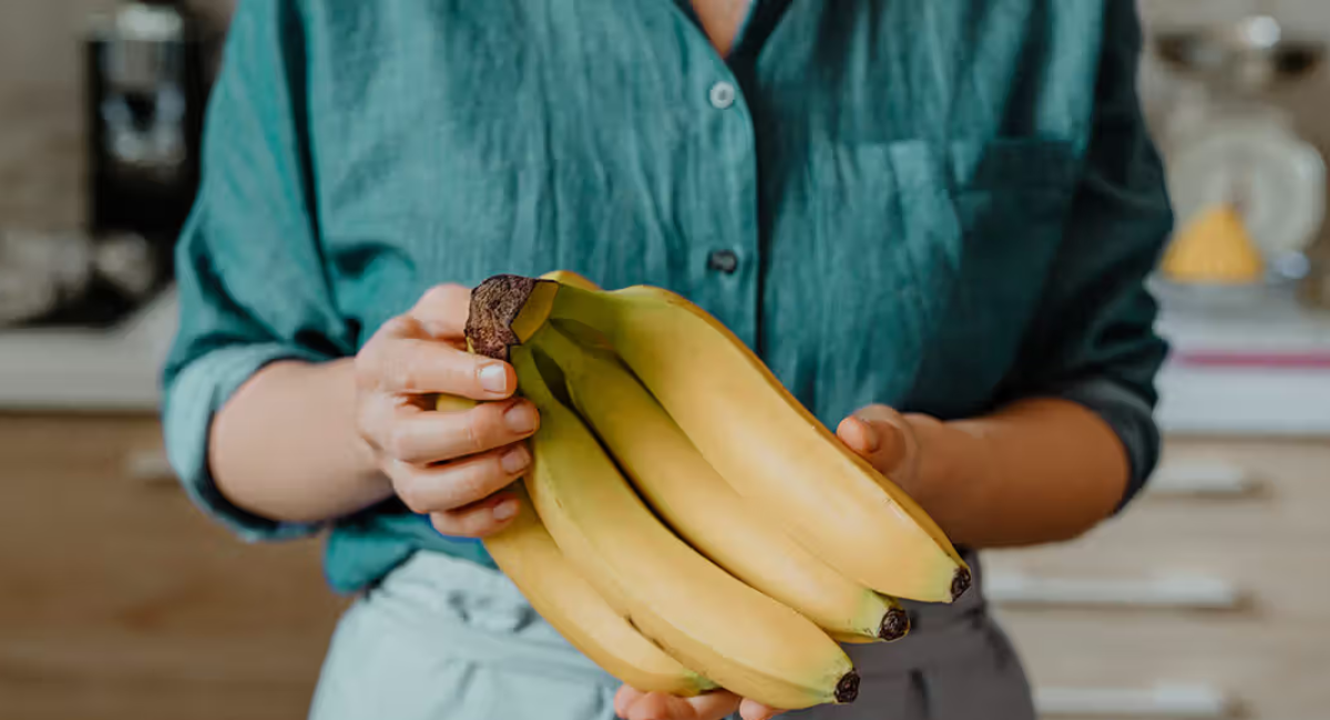 A fresh yellow banana with sliced pieces on a wooden table, highlighting the health benefits of eating a banana every day.