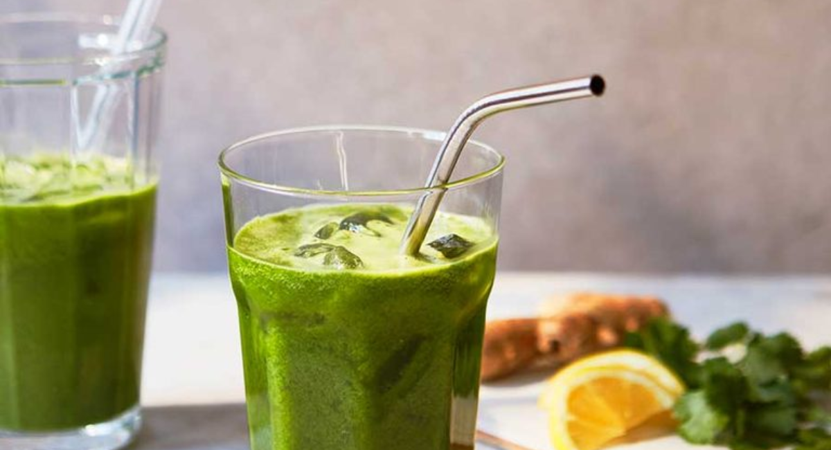 A colorful collection of homemade healthy drinks including fruit smoothies, herbal teas, infused waters, fresh juices, and detox beverages arranged on a kitchen counter.