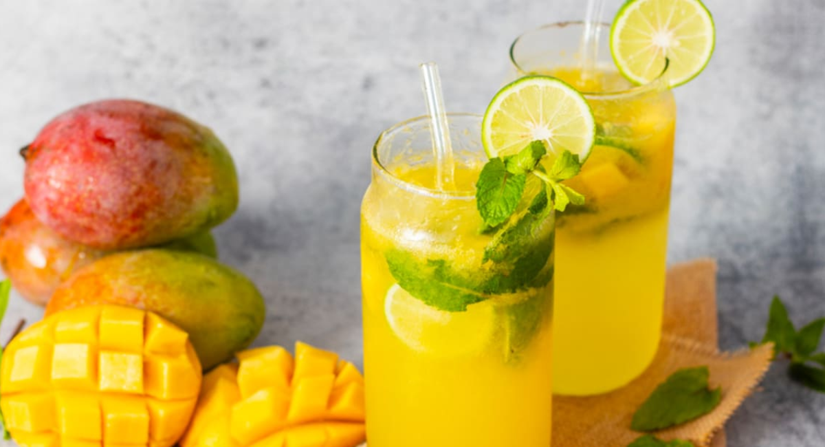 A vibrant layered Butterfly Mango Glow Drink made with mango puree, butterfly pea flower tea, coconut water, chia seeds, and fresh lemon slices in a tall glass.