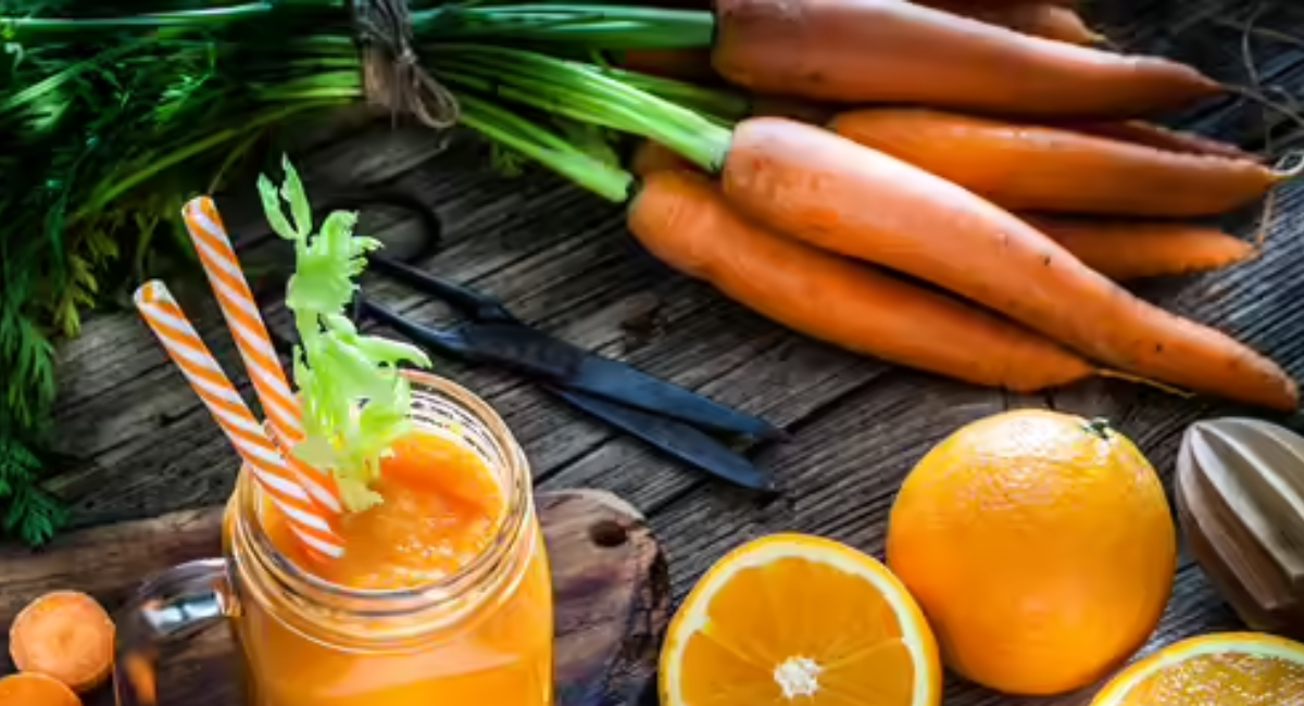 Glass of homemade orange detox juice prepared with oranges, carrots, ginger, lemon, and turmeric, rich in vitamin C and antioxidants.