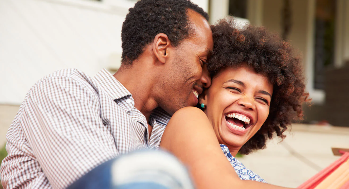 A happy couple talking and smiling together while supporting each other's goals and building a healthy relationship.