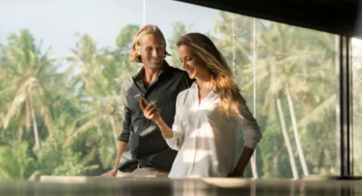 A financially successful professional reviewing investment charts, savings goals, and financial plans on a laptop while organizing money and budgeting documents in a modern office.