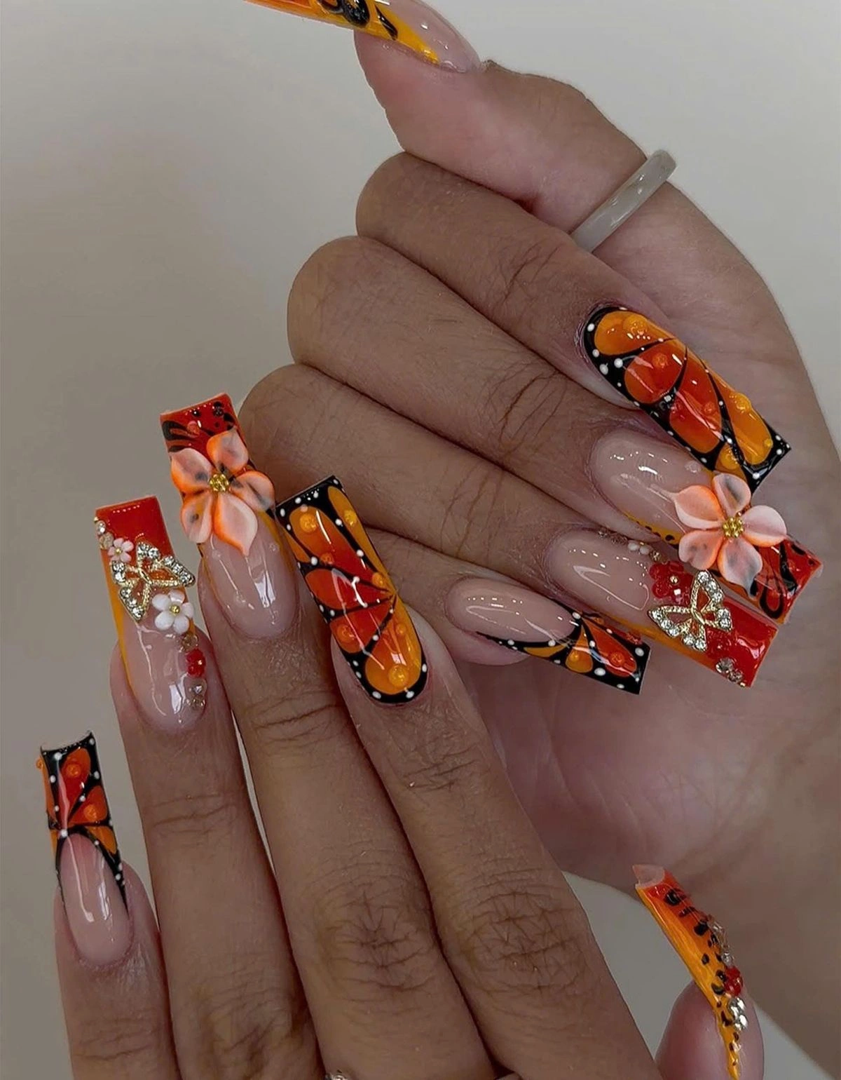 Vintage nail art featuring elegant floral designs, lace accents, pearl embellishments, and glossy nude almond-shaped nails with a timeless retro-inspired manicure.